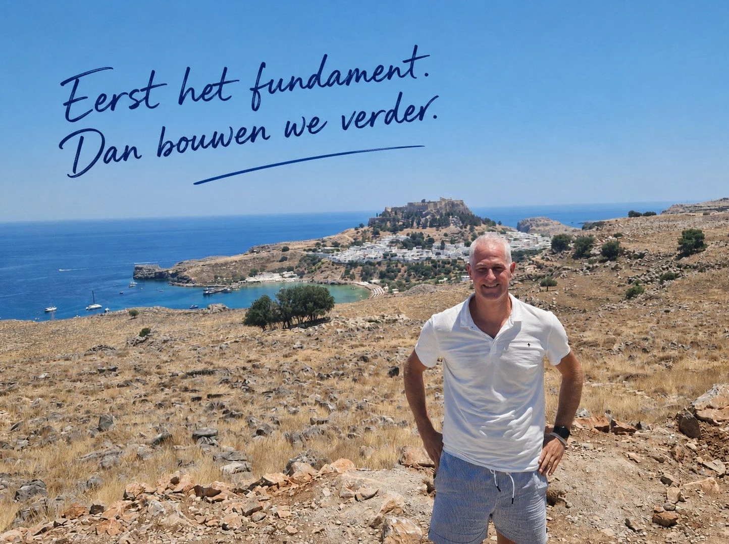Dennis Verhaert voor de Akropolis van Lindos op Rhodos, met daarboven de handgeschreven tekst 'Eerst het fundament. Dan bouwen we verder.'